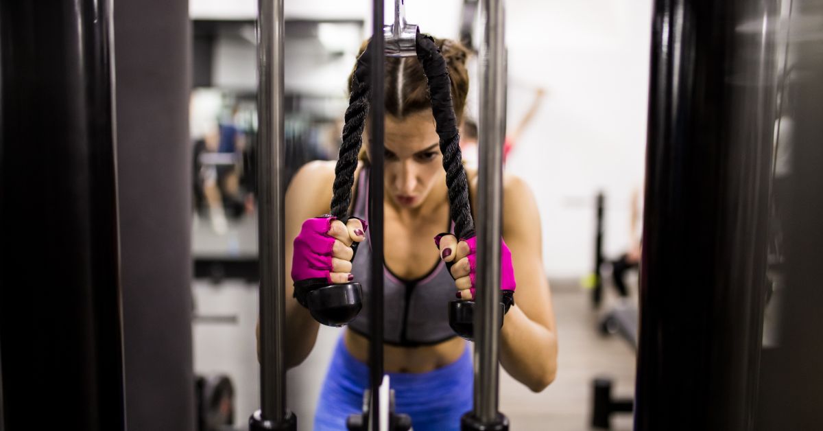 Kvinde træner på multi træningsmaskine